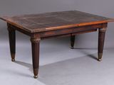 an old wooden table with a leather top on a grey background