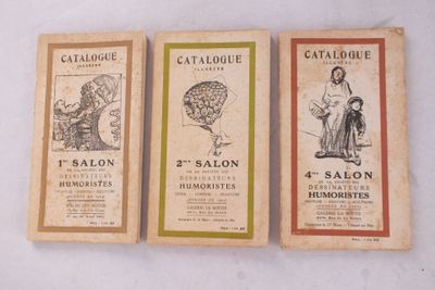 Trois brochures anciennes de salons français sont exposées sur une surface blanche