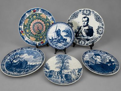 six assiettes bleues et blanches sur lesquelles figurent l'image d'un homme et d'une femme