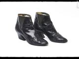 une paire de bottines en cuir noir sur fond blanc