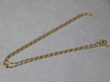 a close up of a gold chain on a white surface