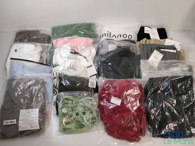 de nombreux types de vêtements différents, rangés dans des sacs posés sur la table