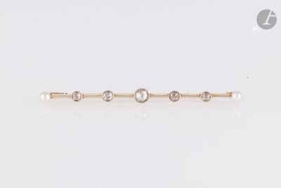 une photo d'une broche en forme de barre, ornée d'une perle et d'un diamant