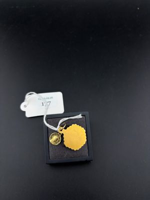 un gros plan sur une breloque en feuille d'or posée sur un coffret noir