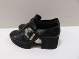 black leather shoes with buckles and a gold buckle on the heel