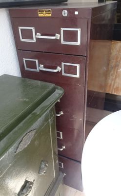 un classeur vert à côté des toilettes dans une salle de bains