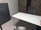 a white desk with a black chair and a black cabinet