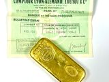 un lingot d'or posé à côté d'un ticket de caisse sur une table