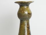 a brown vase sitting on a table with a white background
