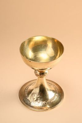 an antique silver plated cup on a stand on a beige background