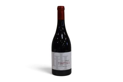 une bouteille de vin rouge posée sur une table blanche