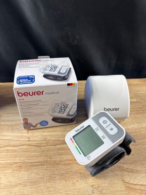 une photo d'un tensiomètre numérique posé sur une table en bois