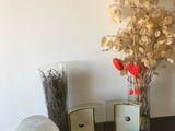 un vase avec des fleurs, un cadre photo et d'autres objets posés sur une table