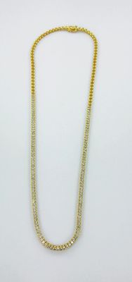 un collier à chaîne en or orné de deux rangées de perles sur fond blanc