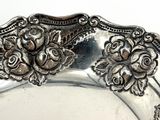 a silver plate with flowers on it on a table