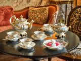 une table sur laquelle sont disposées de nombreuses tasses à thé et soucoupes
