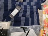 a pile of clothing that includes a shirt, pants, and a cell phone