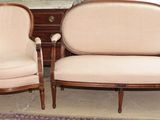 une paire de fauteuils rembourrés dans une pièce où se trouvent une commode et un miroir