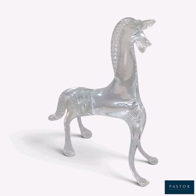 un cheval en verre posé sur une surface blanche