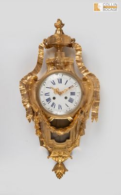 a gold clock with roman numerals and a crown on it
