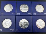 un ensemble de six pièces d'argent présentant des motifs différents