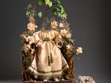 a doll that is sitting in a box with flowers on it