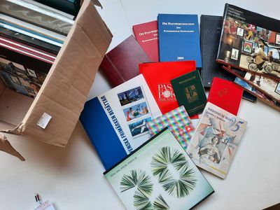 de nombreux livres posés sur une table sur laquelle se trouve une boîte en carton