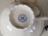 a white cup and saucer with a spoon in it