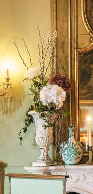 un vase de fleurs posé sur une table devant une cheminée