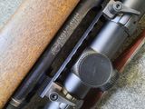 the rifle is laying on the floor next to a knife and other items