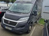 une camionnette noire garée sur un parking à côté d'un immeuble