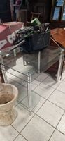 Un bureau moderne en verre piétement chrome.