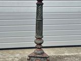 a close up of a metal candle holder on a sidewalk