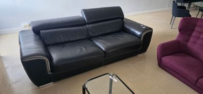 a black leather couch and a purple leather chair in a living room