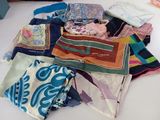 many different types of scarves laid out on a table