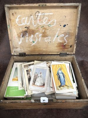 a wooden box filled with religious cards and a chalk board with writing on it