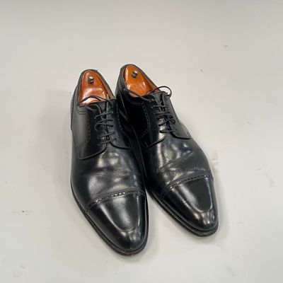 chaussures de ville noires pour homme posées sur une surface blanche