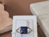a ring with a blue stone in a box on a table