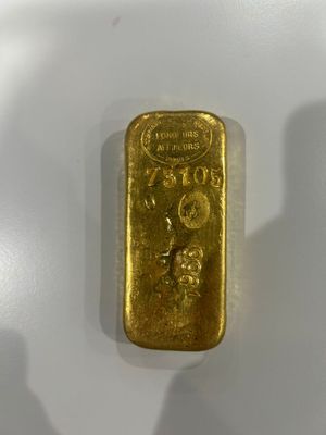 a close up of a gold bar on a white surface