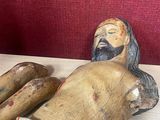 a wooden statue of jesus laying down on a table
