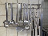 une photo d'une cuisine avec tout un tas d'ustensiles accrochés au mur