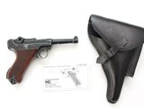 une image représentant un pistolet et un étui posés sur une surface blanche