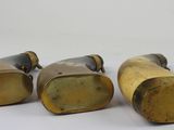 three antique brass candlesticks on a white background