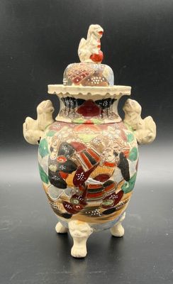 a vase that has a bird on top of it
