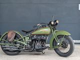 a green motorcycle parked in front of a garage door