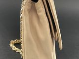 a beige purse with a gold chain hanging from it