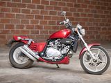 a red motorcycle parked in front of a brick wall