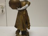 une statue représentant une femme tenant un pot posé sur une table