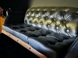a black couch with a guitar on it in a room