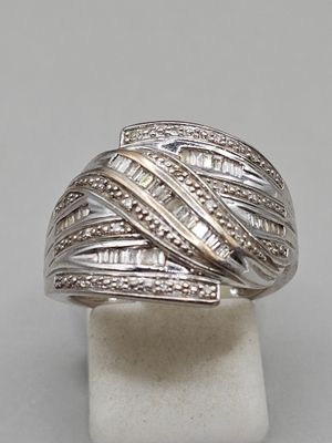 a close up of a silver ring with diamonds on a stand